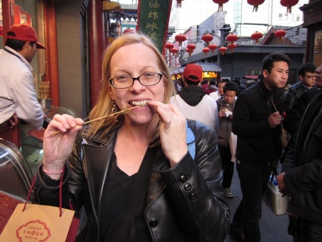 Woman eating scorpions in Beijing, China.