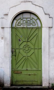 Decorative green door in white frame.