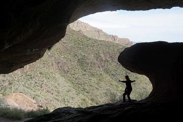 Hiker poses as surfer under the wave rock formation