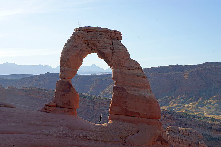 Delicate Arch, a large red sandstone arch in early morning light at Arches National Park.