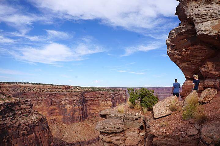 Two hikers at Shafer Canyon Viewpoint Trail standing at canyon rim.