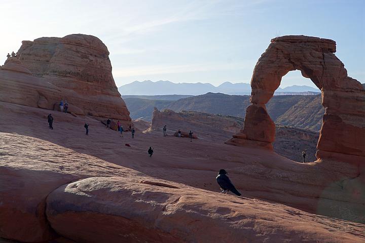 Hikers taking photos and relaxing near Delicate Arch