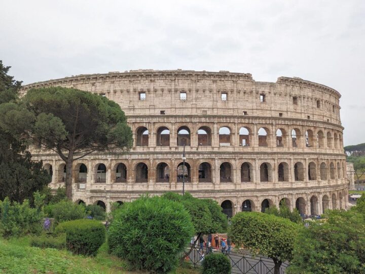 The Colosseum, Rome's historic amphitheatre, viewed from outside on an overcast day.
