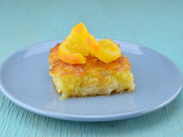 Greek dessert portokalopita on a pale blue plate.