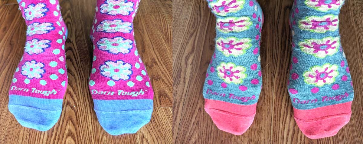 Darn Tough women's flower power hiking socks in pink with blue and pink flowers, and in grey with pink and yellow flowers.