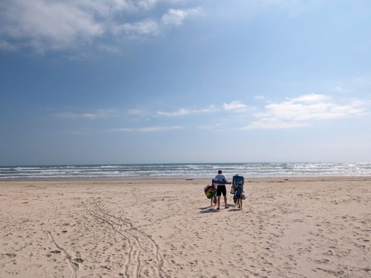 A family walking on the beach at Malaquite Beach Padre Island.