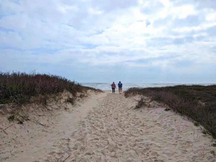 A couple walking towards the water at Malaquite Beach on Padre Island.