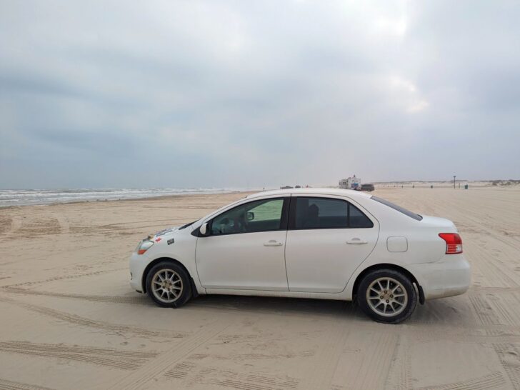 White car on Newport Pass Beach Corpus Christi.