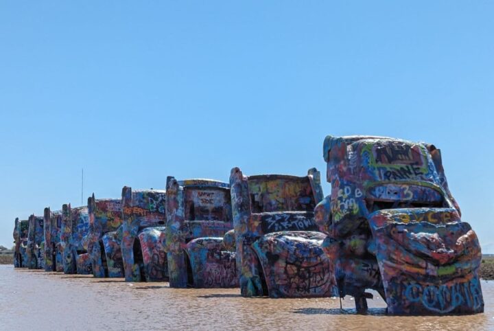 Nine Cadillac cars buries nose-first into the ground and painted all over with graffiti.