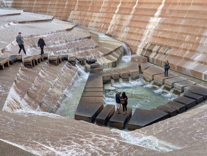 People walking on large concrete blocks by water feature at the Water Gardens Ft Worth.