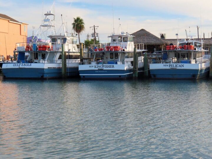 Line of 3 Deep sea fishing boats at Port Aransas marina.