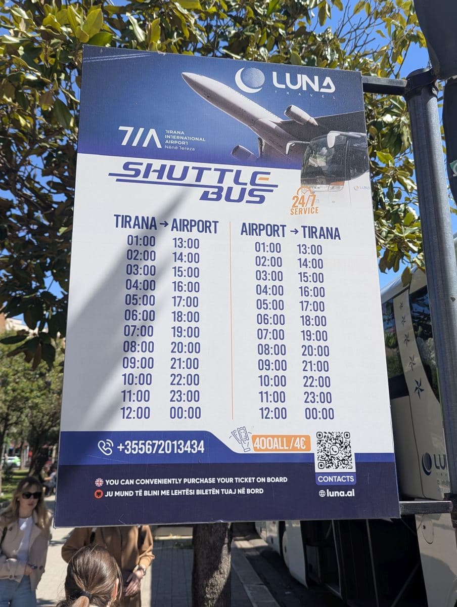 Tirana airport shuttle bus schedule for 24/7 service posted at the bus stop location in central Tirana.